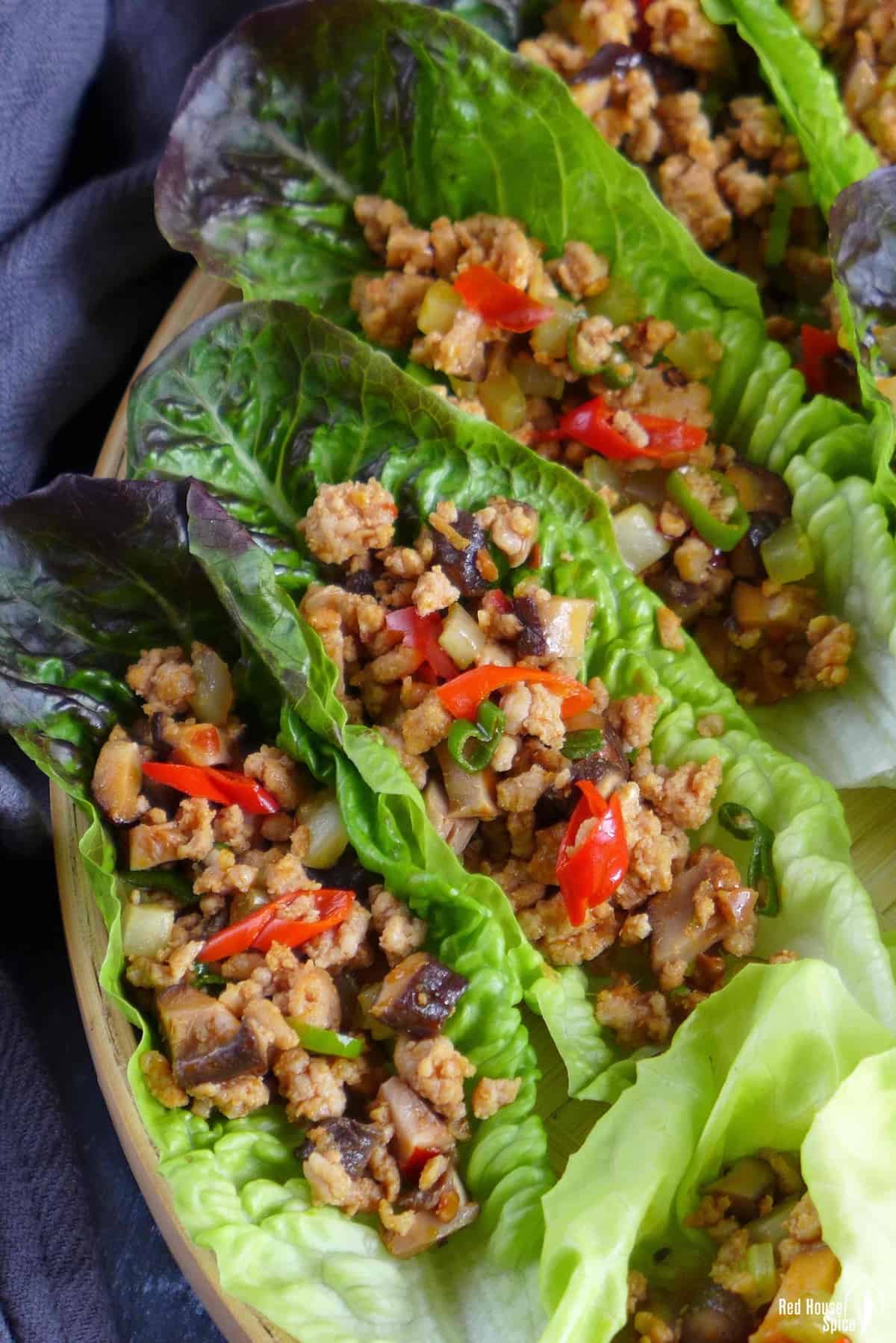 three little gem lettuce leaves topped with cooked minced pork