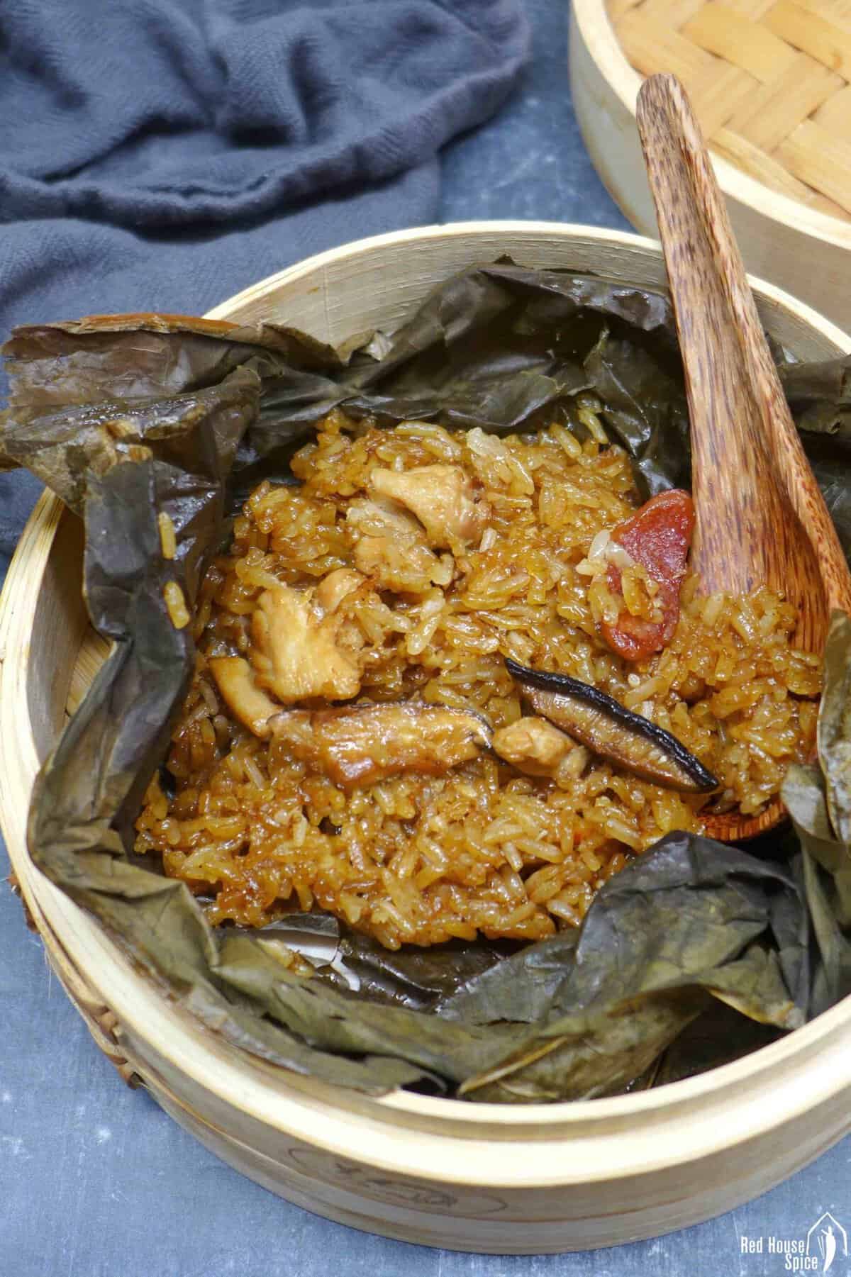 stick rice, chicken, sausage and mushrooms over a lotus leaf.