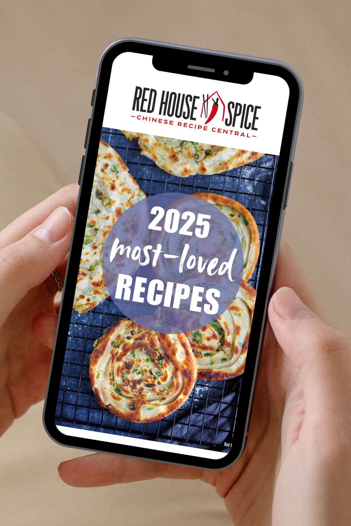 Hands holding a mobile showing the webpage of Red House Spice.