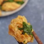 chopsticks picking up a piece of popcorn chicken.
